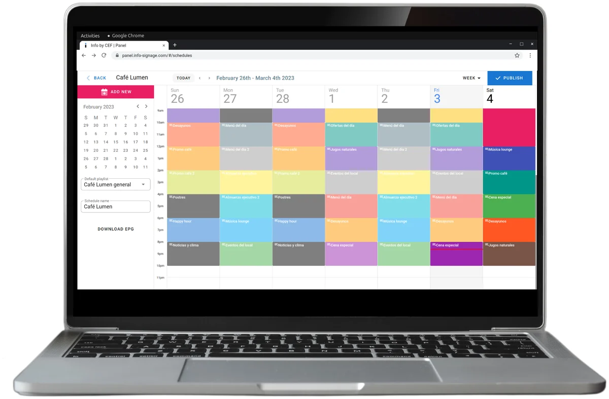 Una laptop con la programación semanal del panel Info: bloques de colores con listas de reproducción por día y hora para una cafetería.
